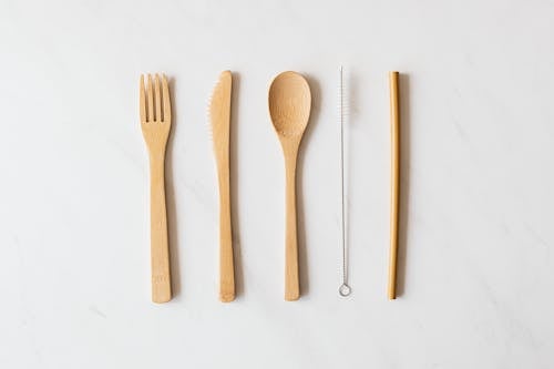 Free Wooden cutlery and tube with brush on marble table Stock Photo