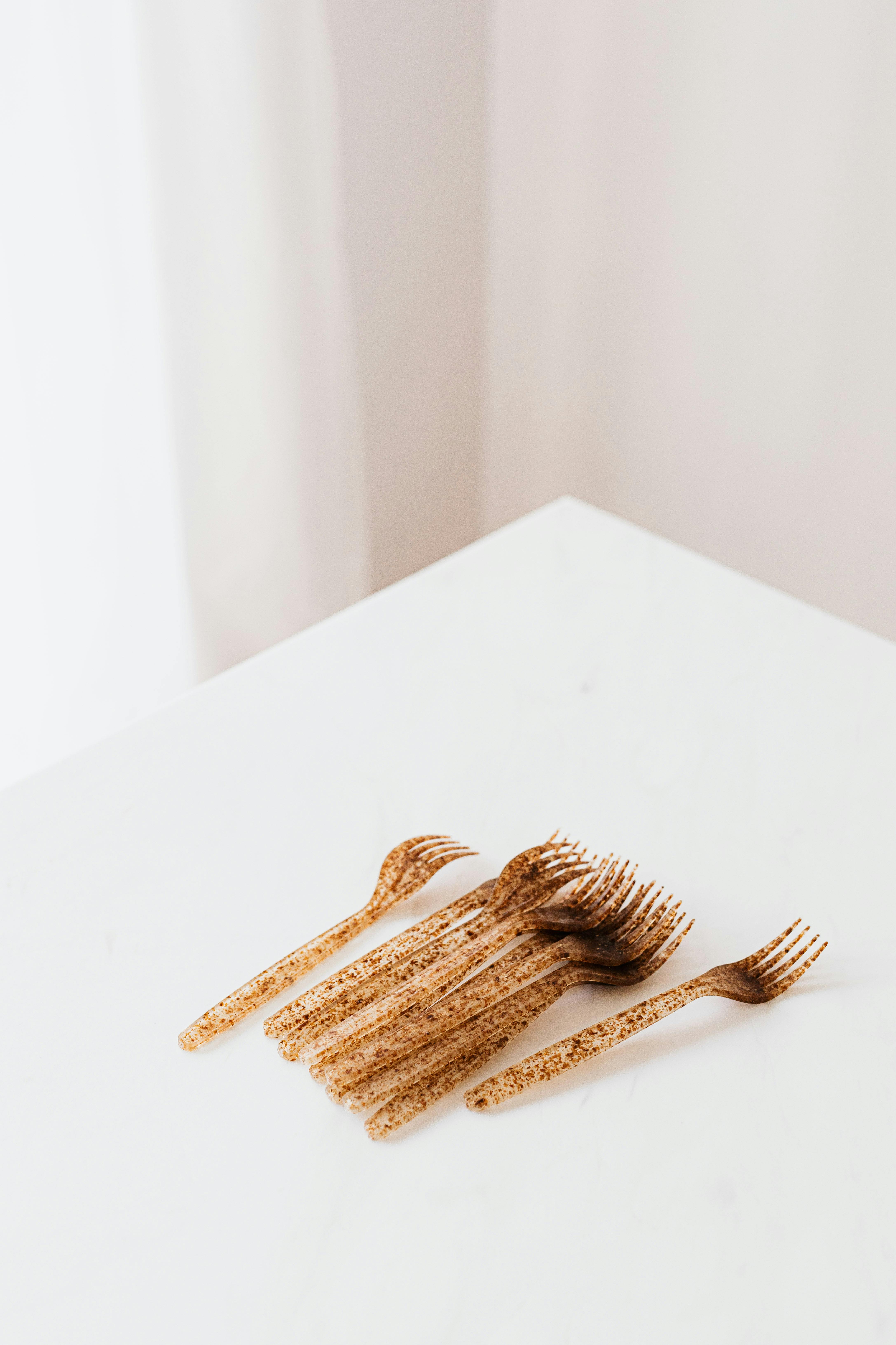 set of golden plastic forks on white table