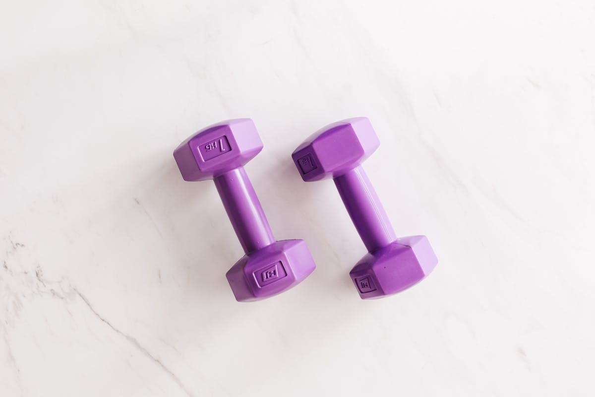 Purple all cast dumbbells on marble surface