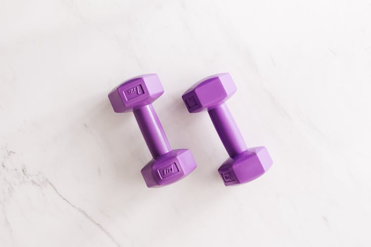 Purple All Cast Dumbbells On Marble Surface