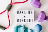 Wake up and workout title on light box surface surrounded by colorful sport equipment