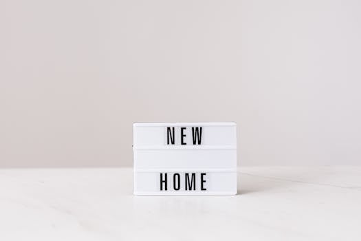 Minimalist lightbox with 'New Home' text on a modern gray background, perfect for real estate or interior design themes.