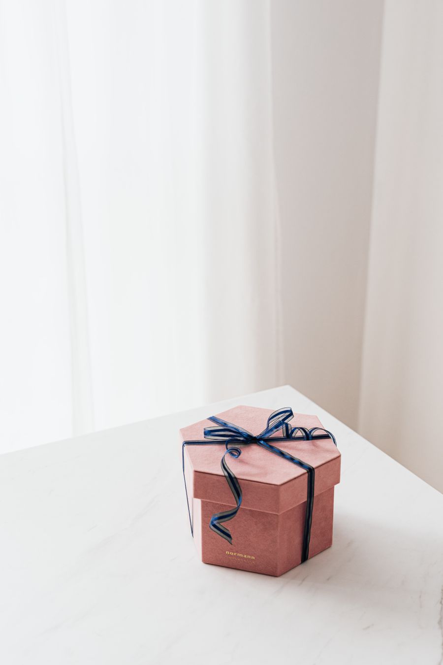 A dusty-rose velvet gift box with fine ribbon
