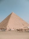 People with horses walking near Pyramid of Cheops largest of Egyptian pyramids monument of architectural art of Ancient Egypt