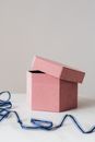 Half opened gift box and ribbon on white table
