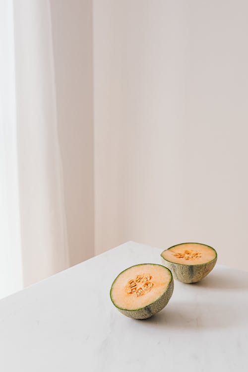 Free White table with halved small melon Stock Photo
