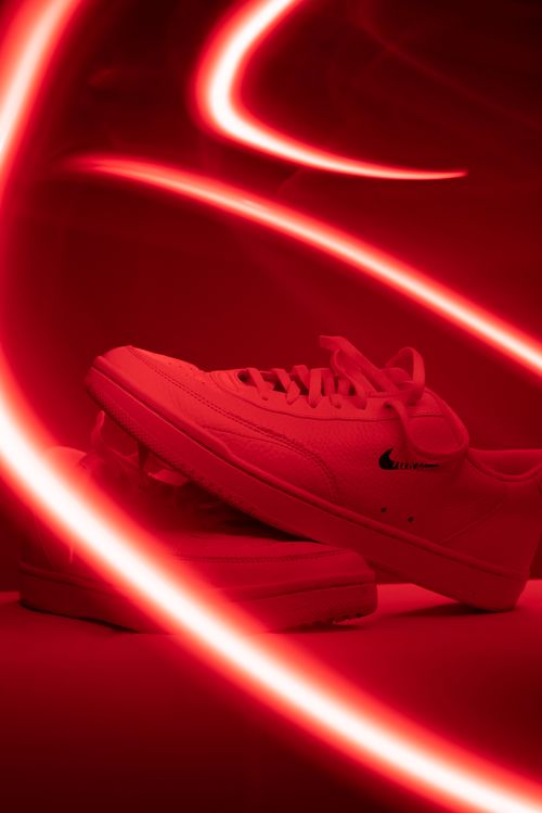 Free Trendy Nike sneakers illuminated by striking red neon lights, capturing a modern and futuristic fashion vibe. Stock Photo