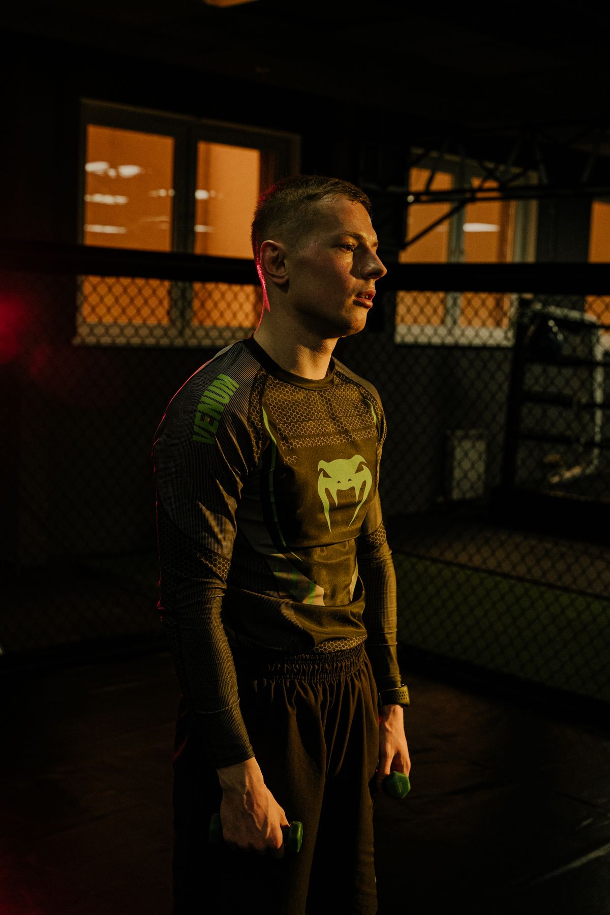 Athlete holding dumbbells inside a modern fitness gym
