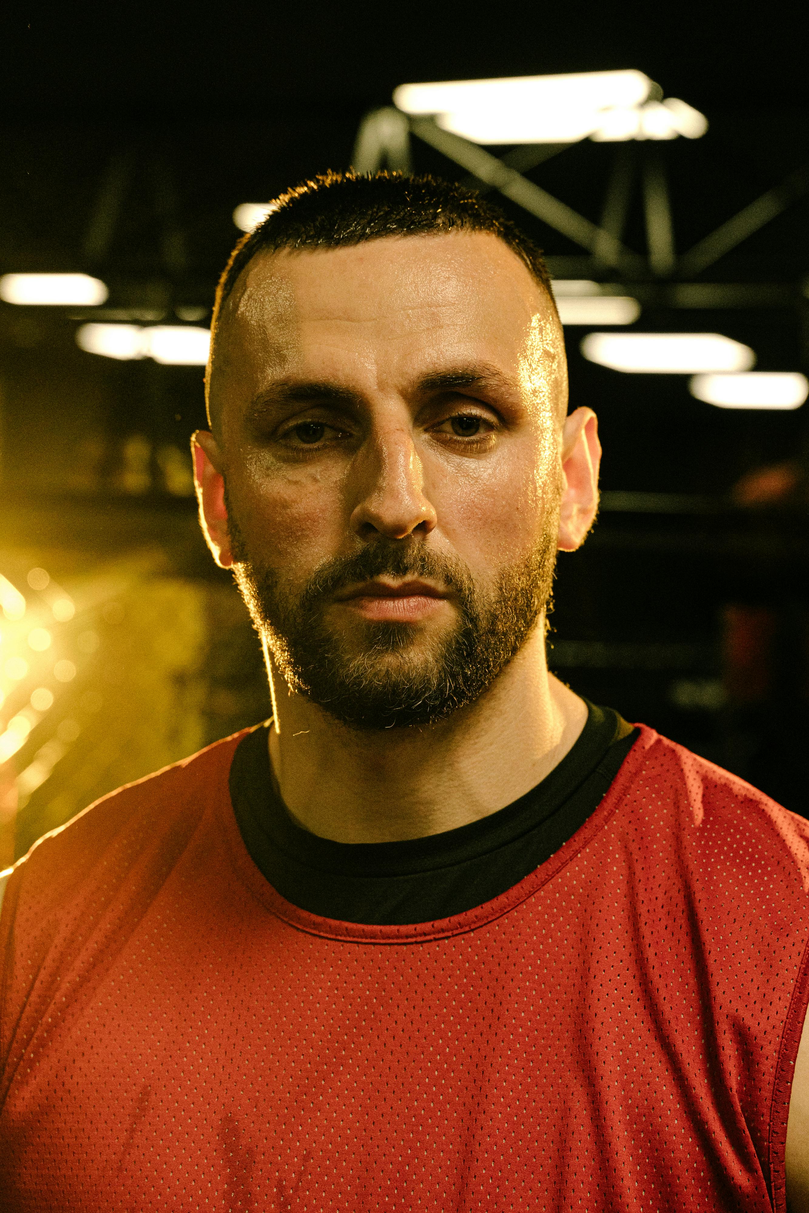 Portrait of a focused athlete in a gym setting with dramatic lighting.