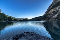 宁静的山间湖泊中，倒映着清晰的树木和蓝天