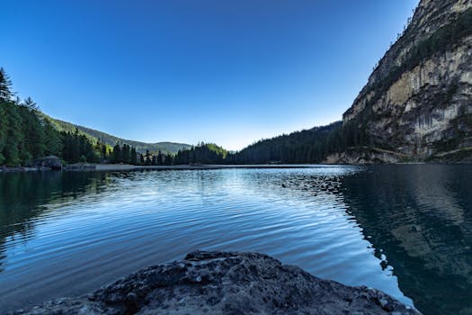 宁静的山间湖泊中，倒映着清晰的树木和蓝天