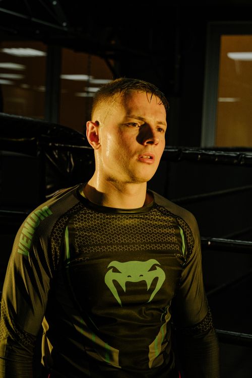 Free Focused male athlete in activewear illuminated by dramatic lighting during training indoors. Stock Photo