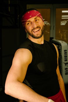 Athlete in gym wearing red bandana and black top, showcasing fitness and boxing spirit.