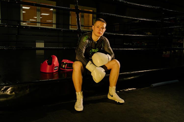 A Man Sitting Wearing Gloves