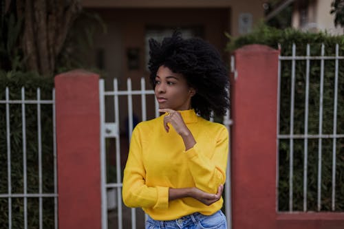 Thoughtful black woman with flowing hair on street