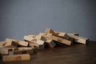 Set of small wooden blocks scattered on table chaotically after playing tower game