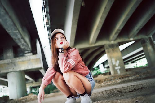 A Woman Sitting Under the Concrete Bridge