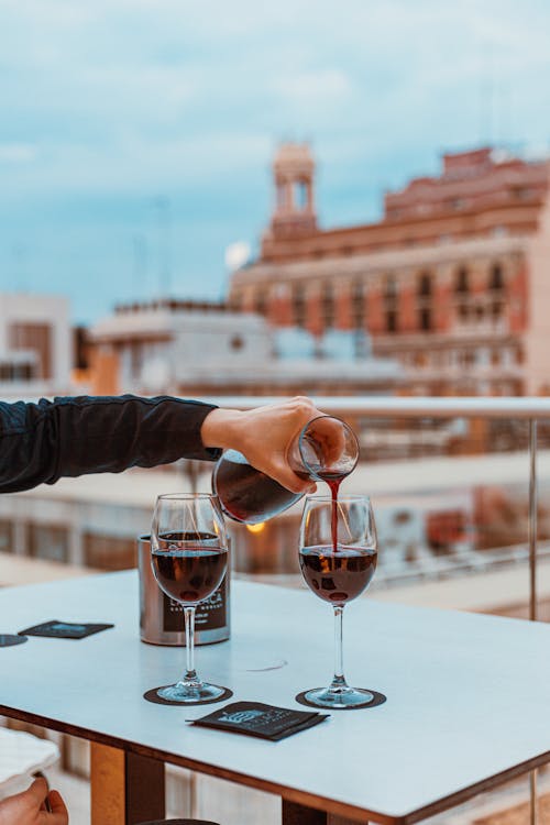 A Person Holding a Pitcher with Wine