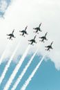 From below of small airplanes flying in sky symmetrically and leaving contrail in air