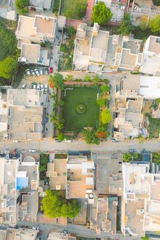Aerial view of a residential district in India showcasing modern architecture and a central green park.