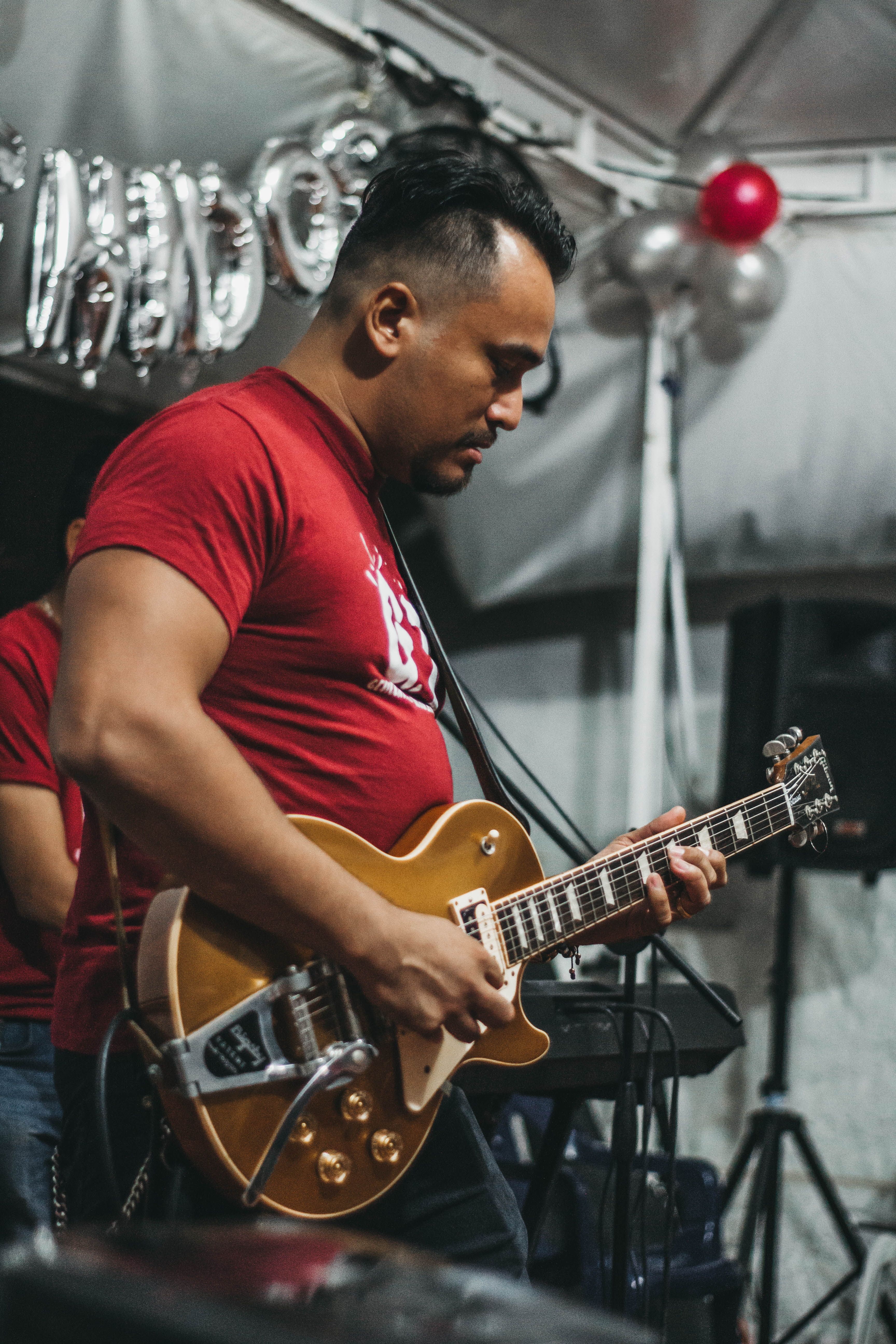 Musician playing electric guitar on stage in vibrant concert setting.