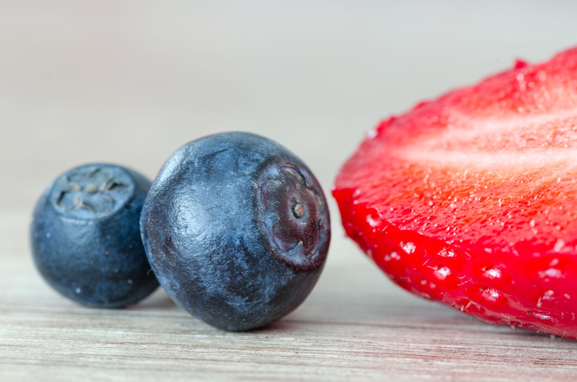 Macro shot of juicy blueberries and a sliced strawberry highlighting freshness and vibrant colors.