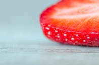 新鲜草莓片在木质表面的生动特写