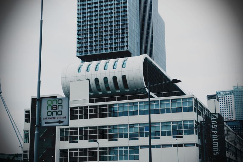 A modern and futuristic skyscraper with distinctive architecture and glass windows in an urban setting.