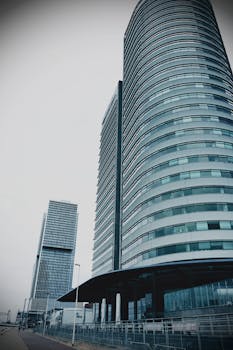 在阴天低角度观看现代玻璃幕墙摩天大楼