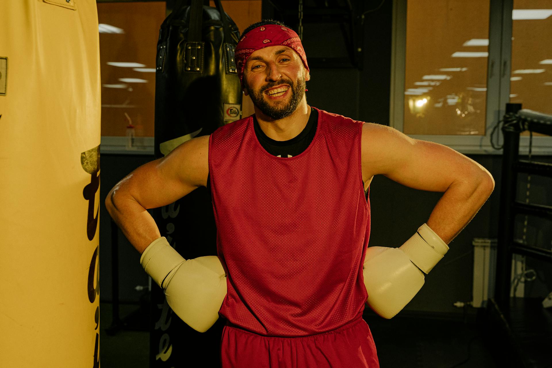 A Smiling Man in Red Tank Top Wearing Boxing Gloves