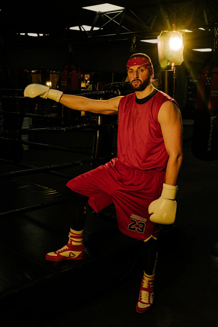 A Man Inside A Gym Holding On The Ropes Of A Boxing Ring