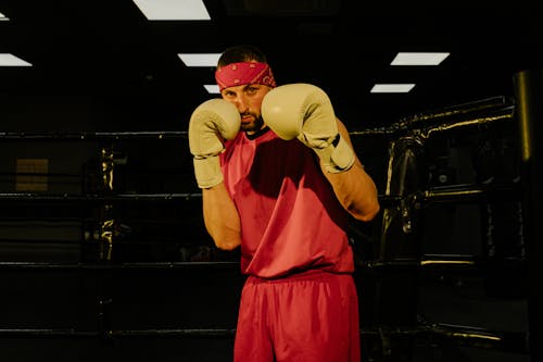 Serious young male boxer training on ring