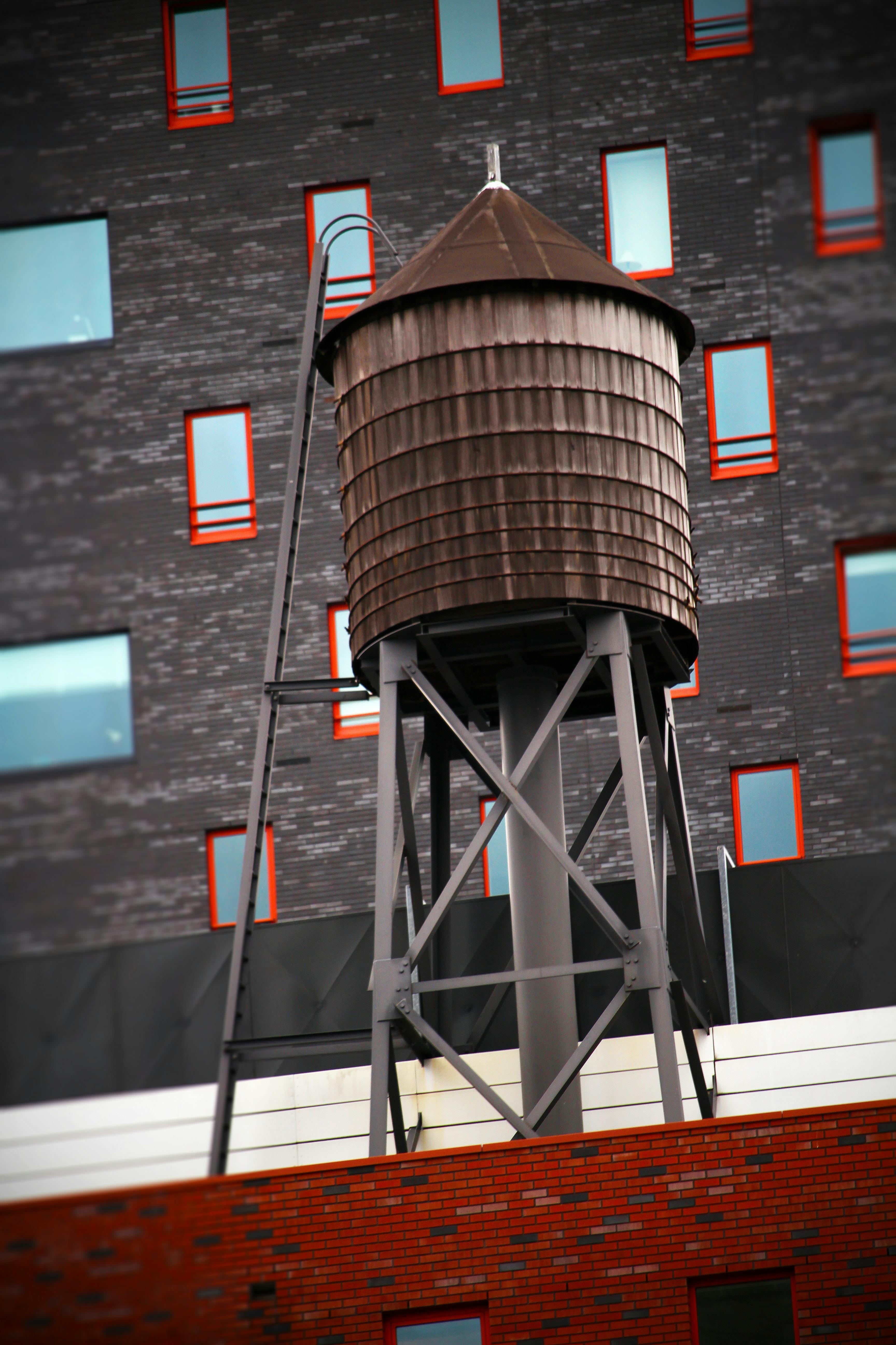 Brown Water Tower on Rooftop · Free Stock Photo