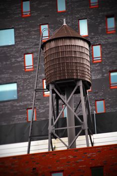 经典的屋顶塔楼背靠现代建筑立面，窗框采用充满活力的红色