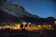 一群成年人在山上的星空下享受篝火