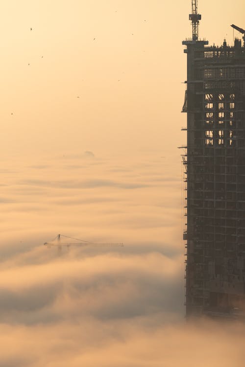 Free A Tall Building over Low Lying Clouds Stock Photo