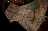 在暗室里，有人从后面匿名检查用蓝色印在大纸上的古董世界地图