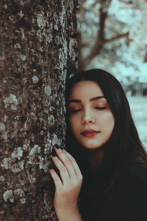 A Woman Leaning on a Tree