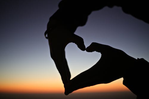 Free Silhouette of a Person's Hands Forming the Heart Shape Stock Photo