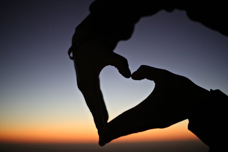 Silhouette Of A Person's Hands Forming The Heart Shape