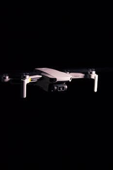 A sleek drone mid-flight against a black background, showcasing cutting-edge technology.