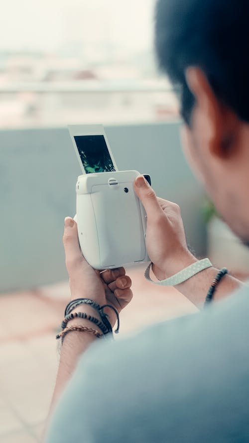 Free A Person Holding a Polaroid Camera Stock Photo