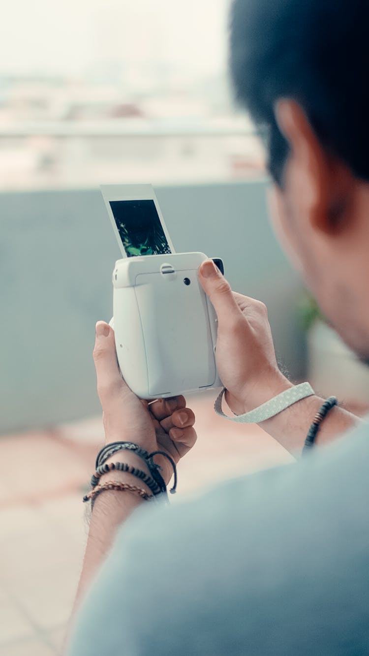 A Person Holding A Polaroid Camera