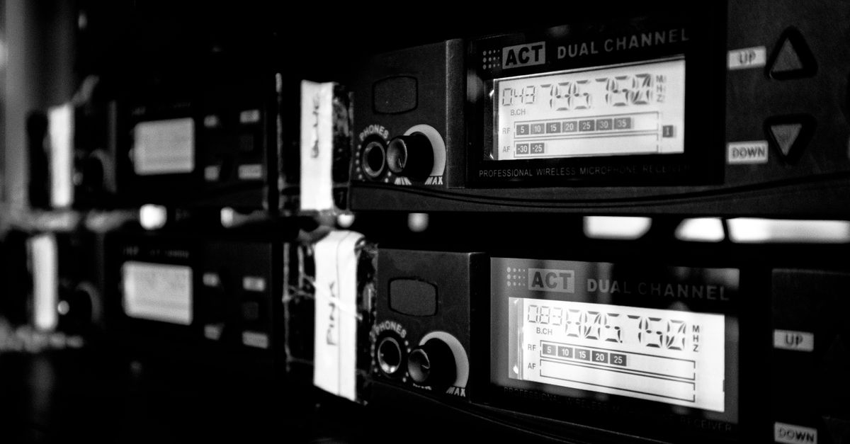 Close-up of dual channel professional wireless microphone receivers in black and white.