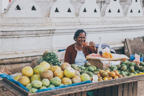 A Fruit Vendor Having a Cup of rink