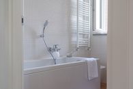 A Bath Towel on Bathtub with Shower Head