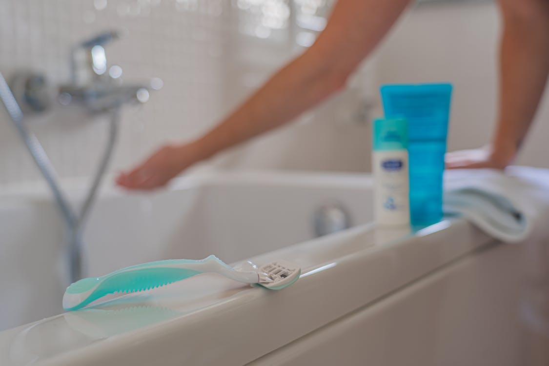 Person Holding White and Green Toothbrush