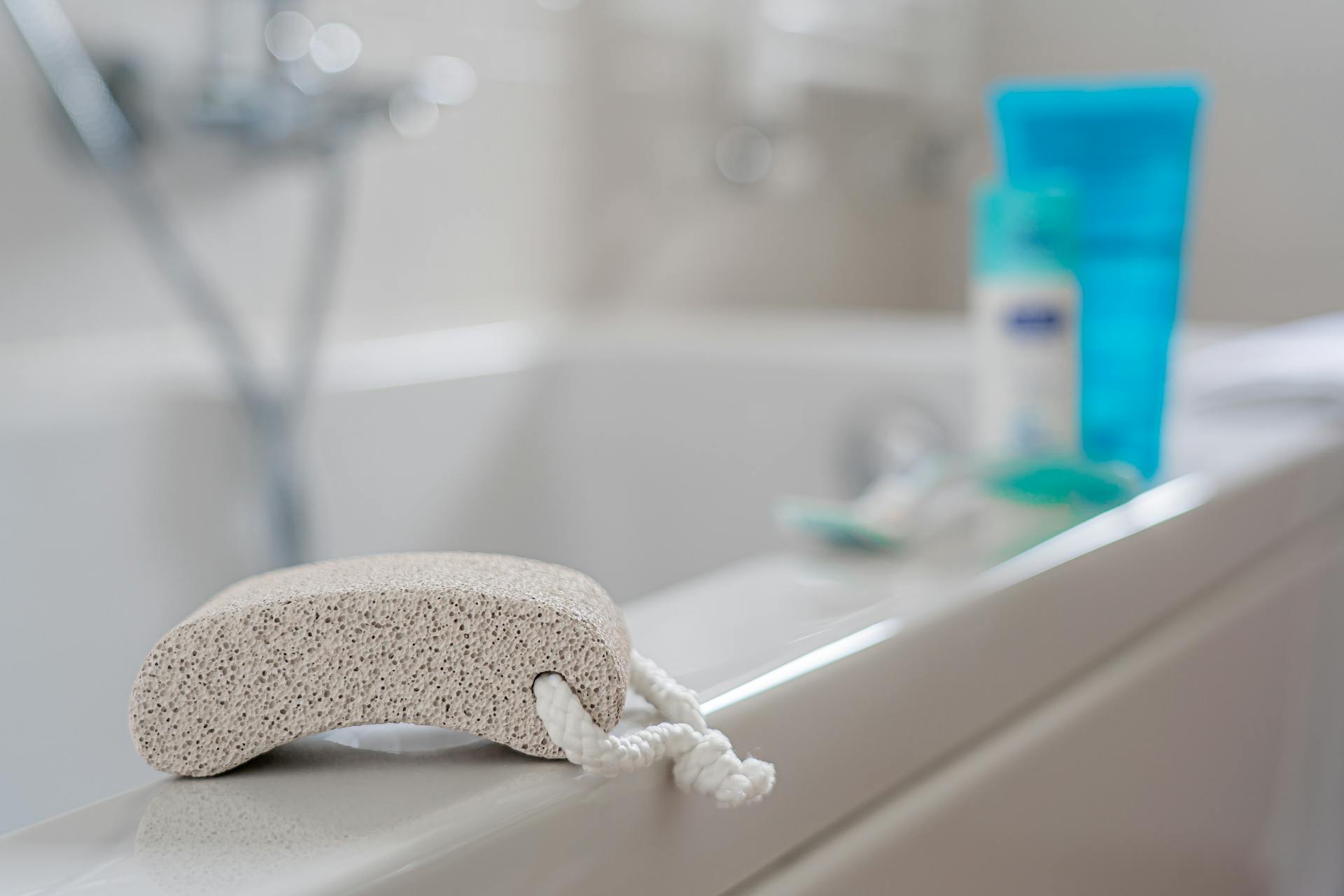 A pumice stone placed on a bathtub edge, ideal for foot care in a contemporary bathroom setting.