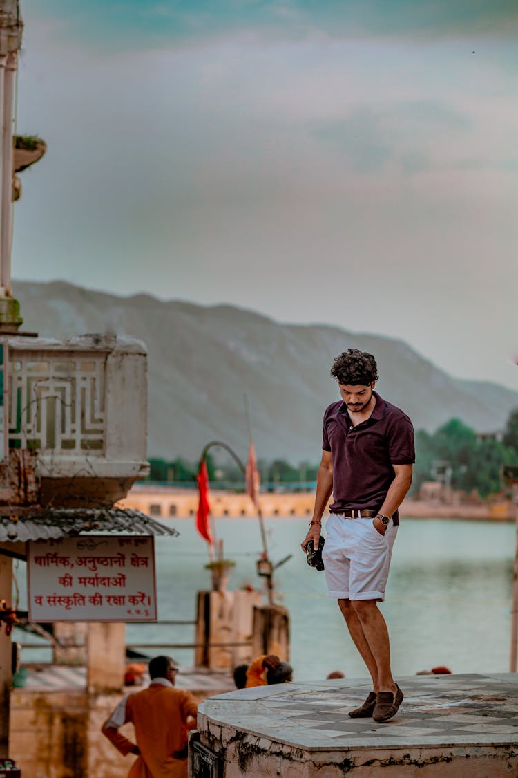 Stylish Ethnic Man On Concrete Platform Behind Lake