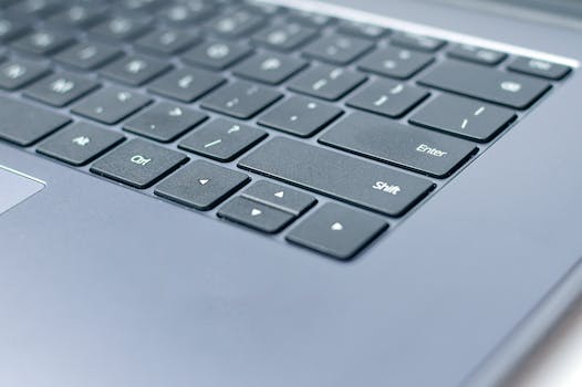 From above closeup of contemporary portable computer keyboard with words and symbols on black keys